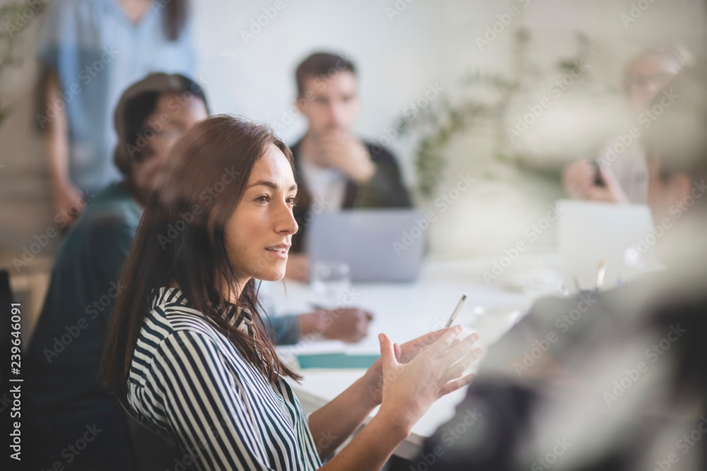 Businesswoman explaining colleagues during meeting in office