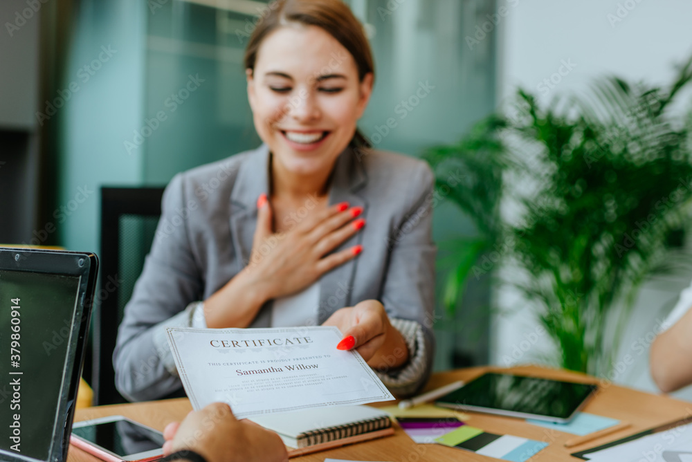 Happy business woman receiving a certificate in office